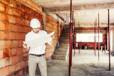 Sitede, kağıt planları okuma ve inşaat işleri denetlenmesi adam çalışan İnşaat endüstri mühendisi