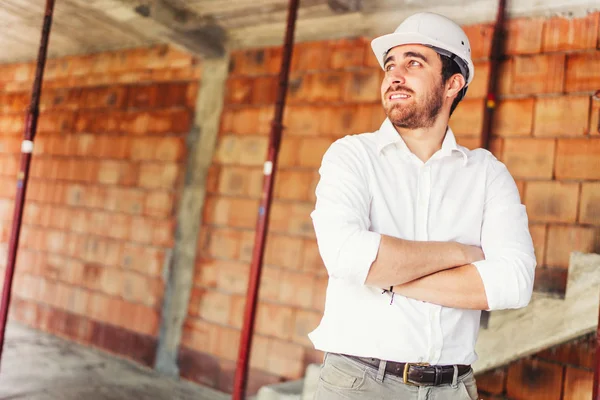 Gülümseyen ve çalışma inşaat sitesinde çalışan mühendis portresi