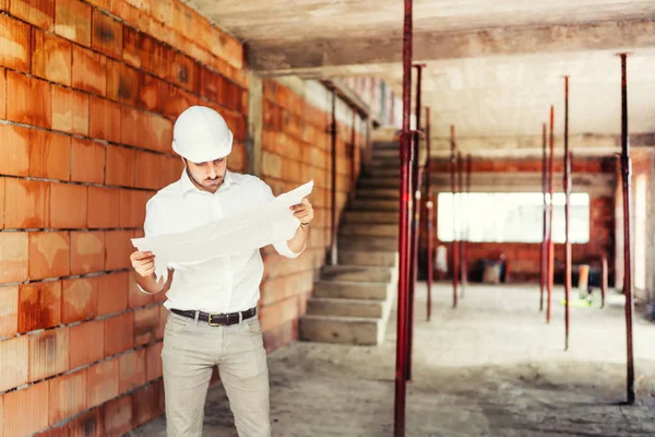 Bauingenieur Arbeitet Auf Der Baustelle Liest Papierpläne Und Überwacht Bauarbeiten — Stockfoto