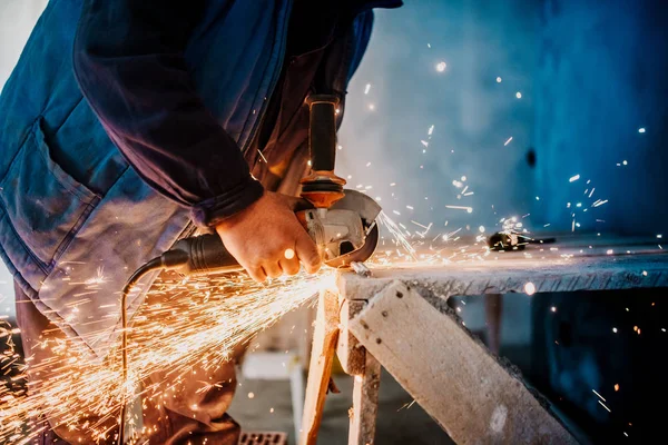 金属工人切割铁和金属与旋转角磨床和工作 产生金属火花 — 图库照片