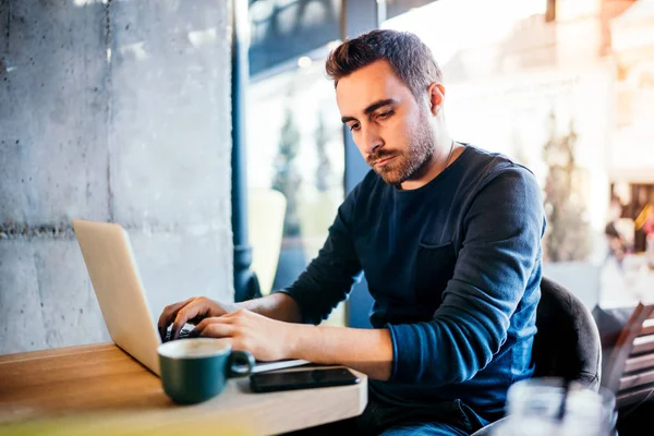Posta gönderme ve Cafe shop kahve yudumlarken bağlı kalmak ciddi genç adam, kendinden emin ve zorlayıcısın. Freelancing kavramı