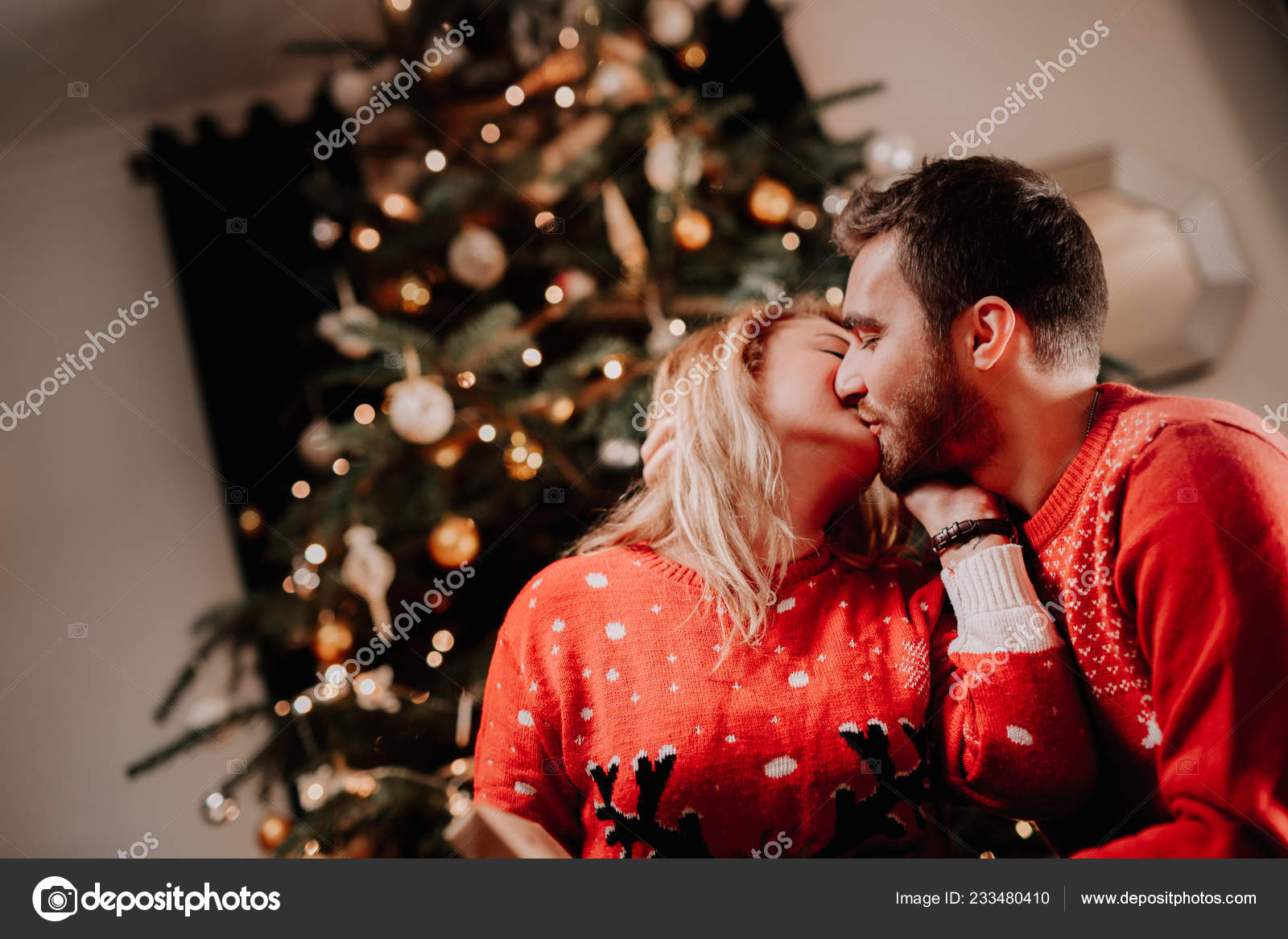 Couple à Noël Avec Coffret Cadeau Dans Leur Salon, Devant Le Sapin