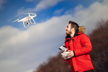Üzerinde mavi gökyüzü uçan adam işletim drone ile havadan fotoğraf ve drone görüntüleri ayrıntıları
