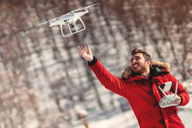 Man operating drone with remote control radio controlled device. Modern technology details