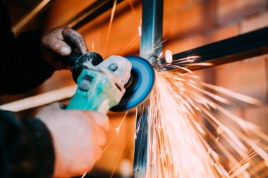 İnşaat sektöründe metal kesme için disk öğütücü kullanarak metalworker