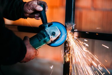 Sanayi işçisi, işçiler elleriyle güç aracı dairesel bıçak öğütücü ile yakından