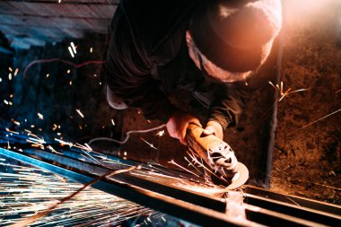 Sanayi işçisi şantiye ve fırlatma açısı değirmeni kullanarak kıvılcım. Metal korkuluk üretim