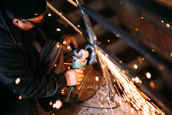 金属工人切割铁和金属与旋转角磨床和工作 产生金属火花 — 图库照片