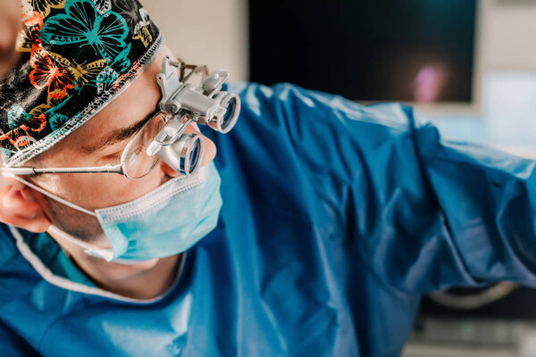 Close up portrait of Surgeon performing surgery on pacient in hospital operating room.