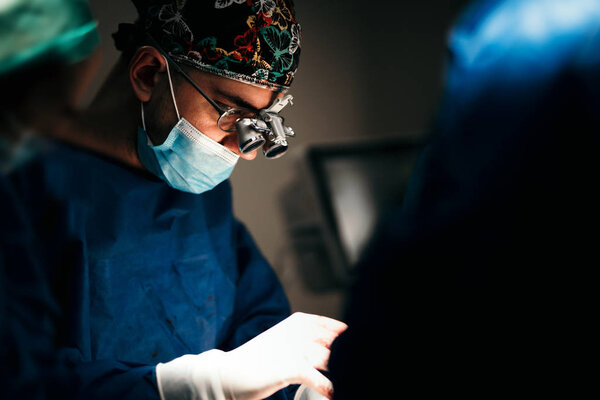 Portrait of surgeon performing in operation theatre. Close up portrait of surgical doctor performing operation in surgery room. 