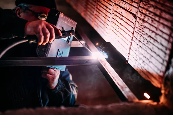 Industrial Worker laborer at the construction site, welding steel structure — Stock Photo, Image