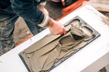 taşla çalışan işçinin yakın çekim, mala ile yapıştırıcı ekleyerek