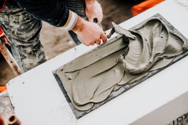 Taş montajı için mala ve harç kullanan işçinin ayrıntıları