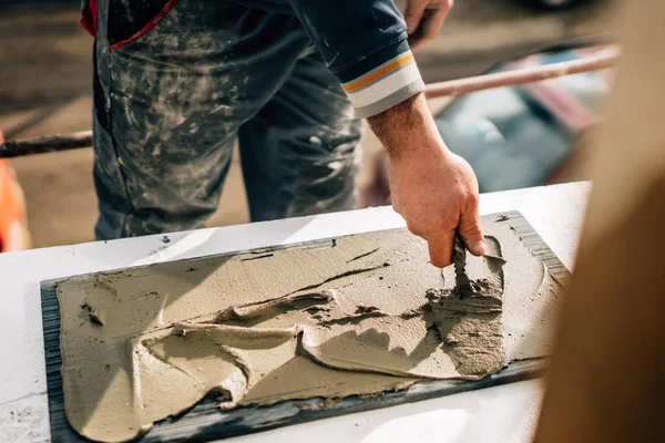 Industriële werknemer met behulp van Troffel en gereedschap voor het bouwen van buitenmuren met steen en mortel en lijm — Stockfoto