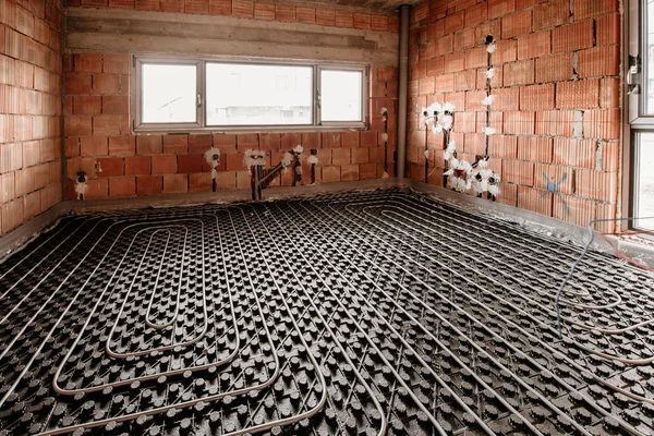 Details of underfloor heating and cooling during house construction. Plumbing details of flexible tubes and central heating system