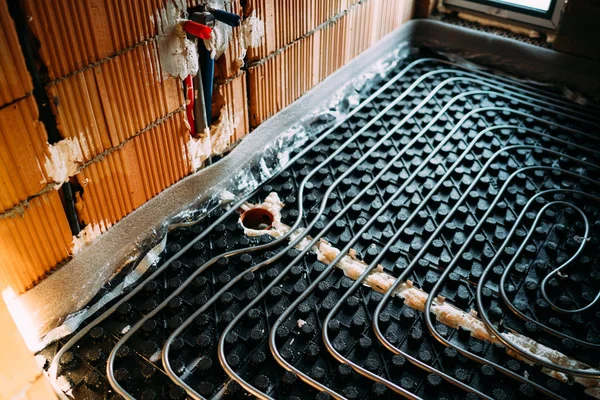 Vloer verwarmingsysteem met pijpen, buizen en warmtepomp — Stockfoto