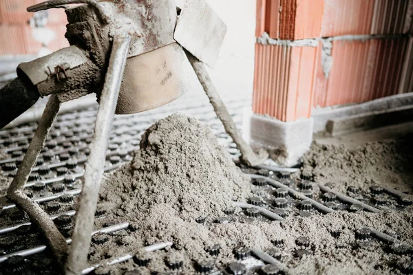 Detalhes de close-up de argamassa de cimento e bomba de concreto durante construções interiores — Fotografia de Stock