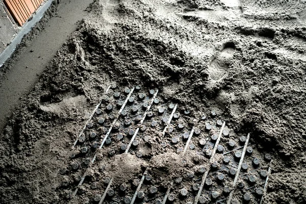 Zand en cement dekvloeren over vloerverwarming op nieuwbouw plaats — Stockfoto