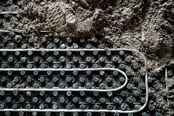 Laborer leveling sand and cement screed over floor heating — Stock Photo, Image