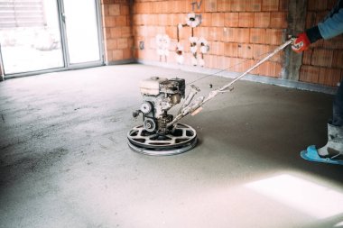 İnşaat sanayi işçisi mala makinesi ile beton şap bitirir