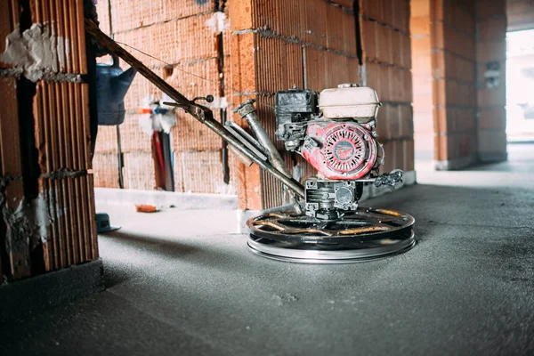 Helicopter concrete floor finishing on construction site. Construction worker finishing concrete screed with power trowel machine — Stock Photo, Image