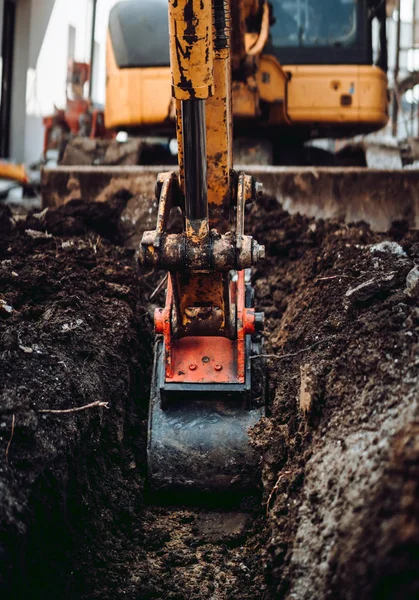 Escavadora de serviço pesado usando pequena colher para cavar no local de construção — Fotografia de Stock