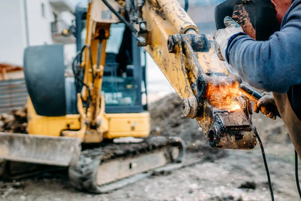 Professionell arbetstagare svets grävmaskin arm på byggarbetsplatsen — Stockfoto