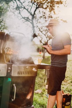 Barbekü partisi, ızgara ve arkadaşlarınızla bir pazar günü bahçede pişirme