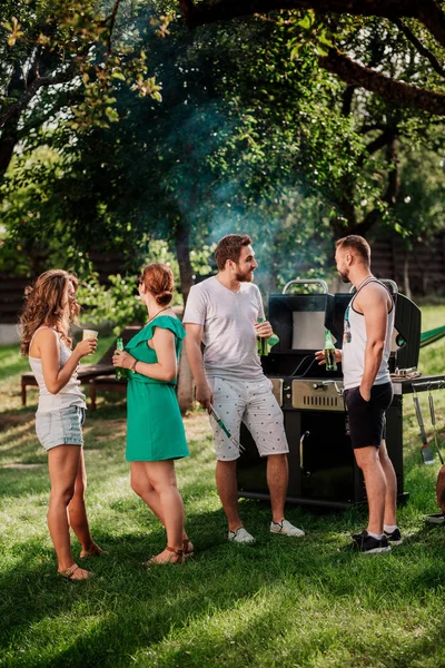 Pessoas que fazem uma festa de churrasco com bebidas, comida e cozinha ao ar livre. Conceito de acampamento com amigos e pessoas — Fotografia de Stock