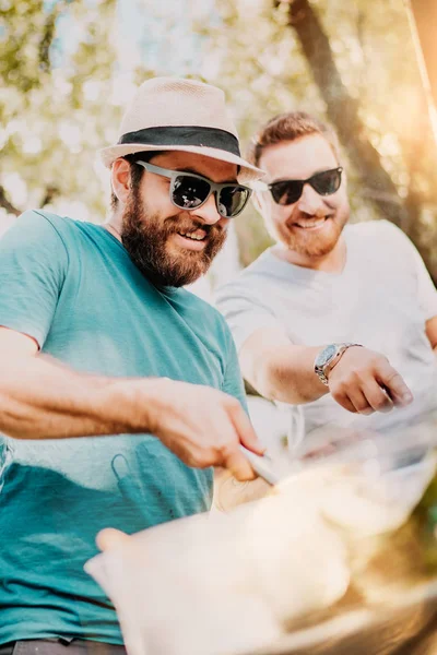 Retrato de dois amigos do sexo masculino cozinhar na churrasqueira . — Fotografia de Stock