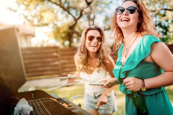 Двоє друзів проводять вечірку на барбекю в саду, на заході сонця — стокове фото