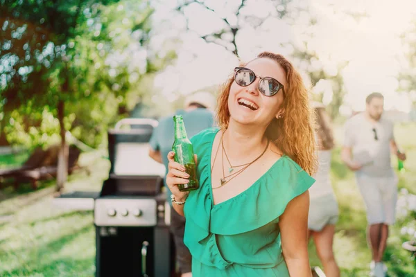 Retrato de mulher sorridente tomando uma bebida com amigos na festa do jardim — Fotografia de Stock