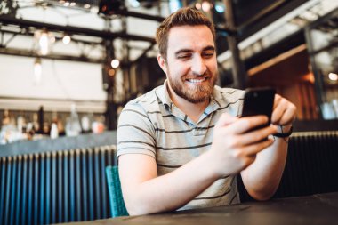 Kredi kartı ile yeni, modern temassız teknoloji kullanarak öğle yemeği için ödeme mutlu gülümseyen müşteri