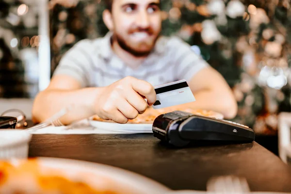 Close up retrato do homem que paga com cartão de crédito no restaurante. Concentre-se em mãos, cartão e terminal de pagamento — Fotografia de Stock