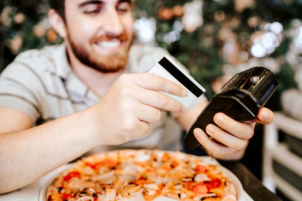 Homem sorridente pagando no restaurante usando tecnologia sem contato, cartão de crédito e terminal sem fio — Fotografia de Stock