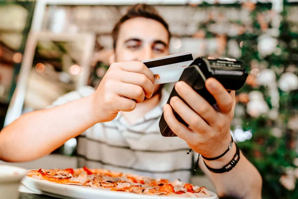 Homem sorridente pagando no restaurante usando smartphone. tecnologia de pagamento móvel com cartão de crédito sem contato — Fotografia de Stock