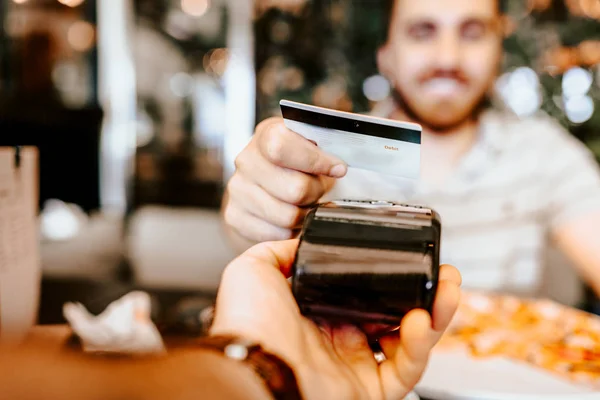 Cliente feliz que paga para o almoço usando a tecnologia contactless nova, moderna com cartão de crédito — Fotografia de Stock