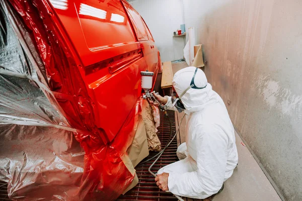 Portrait de peintre travaillant et peignant une voiture rouge en garag peinture — Photo