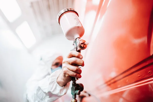 Close-up van mannelijke holding spray Gun en het schilderen van een auto — Stockfoto