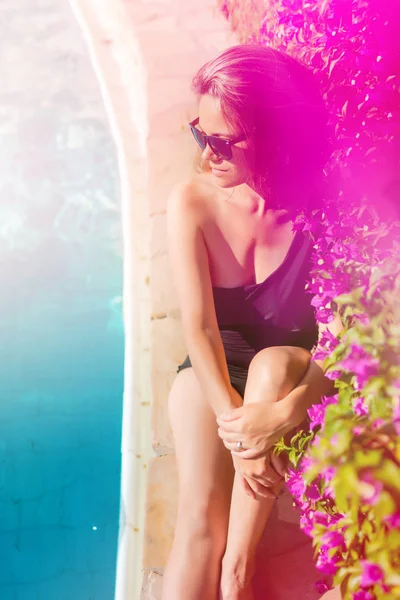 Porträt einer schönen und sexy Frau mit Sonnenbrille am Pool, die sich schön bräunt — Stockfoto