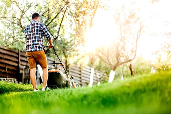 Detalles de jardinería, jardinero industrial trabajando con cortacésped y cortando hierba en garde — Foto de Stock