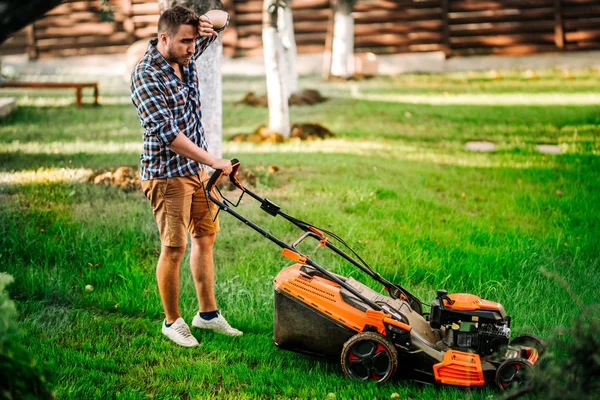 Retrato del jardinero trabajador que usa cortacésped y corta hierba —  Fotos de Stock