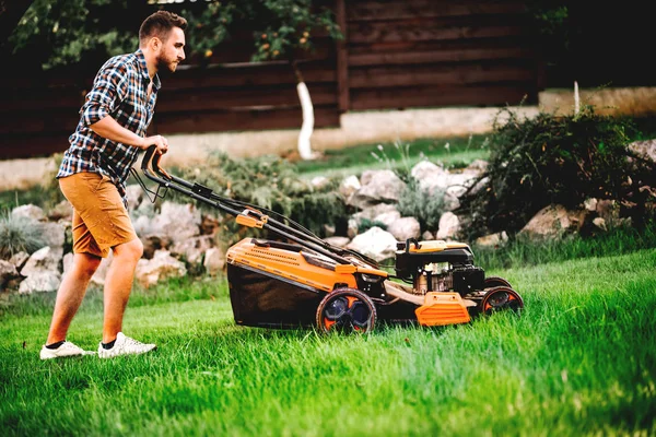 Porträt eines Gärtners, der den Rasen mit einem professionellen Rasenmäher mäht — Stockfoto