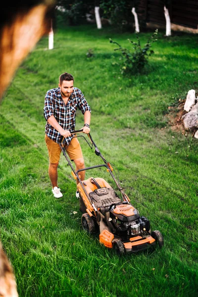 ガーデニングの詳細、芝刈り機で作業する産業庭師、ガードで草を切る — ストック写真