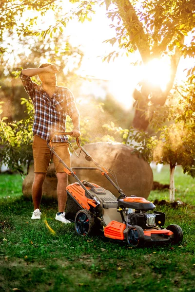 Bahçe ve peyzaj detayları, işçi, bahçıvan bir çim biçme makinesi ile kullanarak ve garde çim kesme