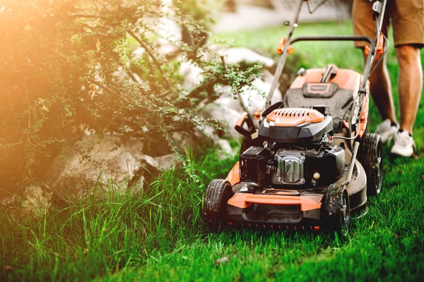 ガーデニングの詳細、芝刈り機を使用し、ガードで草を切る産業庭師 — ストック写真