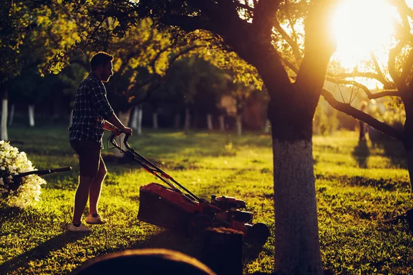 芝刈り機を使用してハンサムな白人の庭労働者の肖像画 — ストック写真