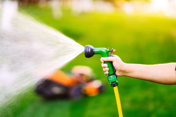 Gros plan des mains de jardinier travaillant dans le jardin, en utilisant des tuyaux et des plantes d'arrosage — Photo