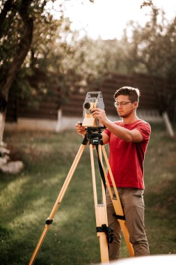 Peyzaj projesinde toplam istasyon teodoliti ile çalışan eksper mühendisi