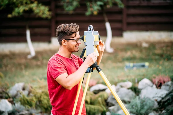 Equipamento de engenharia de vistoria com teodolite e estação total em um jardim em um canteiro de obras — Fotografia de Stock